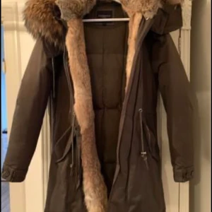 Jacka från Cedrico  - Monet från Cedrico Snygg vinterjacka i en xxsmal modell. Härlig stor äkta päls.  Vinterjacka i en smal snygg modell med riktigt härlig äkta päls. Monet från Cedrico Norway. Fina skinndetaljer, både pälsen och huvan är avtagbara. Dragsko i nederkant, samt två blixtlåsförsedda fickor och två knappförsedda fickor fram. klassisk dun/fjäder stoppning.  Använd 3 gånger - nyskick! Nypris  8500kr