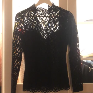 Svart långärmad spetströja  - Storlek S. Passar även xs då den är tight i modellen. Fin att ha instoppat i byxor. Mycket fint skick 