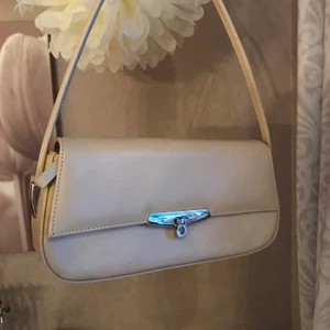 Brun baguettväska  - En snygg beige/ljusbrun baguettväska med dragkedja, i superfint skick🤎  80+frakt.  Längd: 27cm, Höjd: 13cm, Djup: 5cm