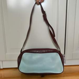 En ljusblå och vinröd Y2k handväska med några små fläckar, men annars i fint skick.