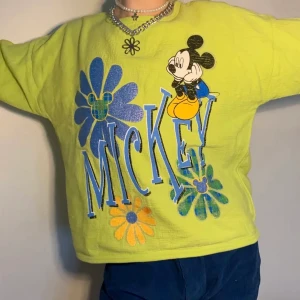 Grön retro Mickey Mouse graphic sweatshirt  - Så härlig limegrön retro sweatshirt med ”Mickey” i en underbar klarblå font samt lätt glittriga blommor i blå, grön och gul plaid + Musse Pigg himself! 🍀 perfekt avslappnad siluett samt lagom starka färger som passar såå bra med ett par dark wash jeans och accessoarer i matchande färger!  Alla priser är inkl. frakt och alla plagg tvättas innan de skickas iväg