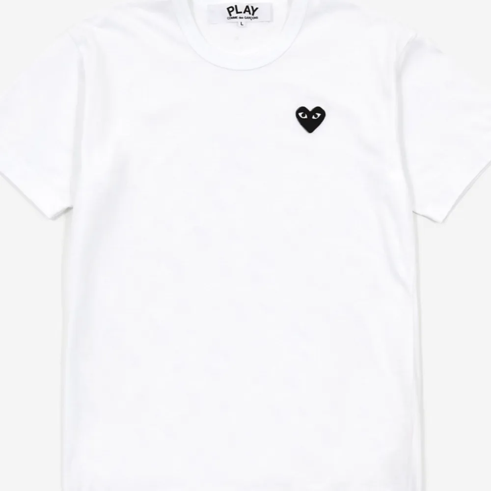 Vit cdg T-shirt med svart hjärta, storlek är m men den är väldigt liten så skulle säga att den passar en xs, börjar bli liiite nopprig i tyget . T-shirts.