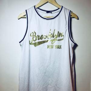 Kort klänning /långt basket linne modell med texten Brooklyn new york i guld. Köpt på Asos och använd fåtal ggr. (Frakt tillkommer om du ej kan hämta på plats)