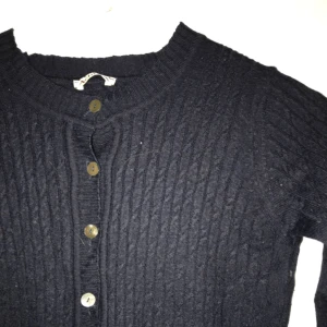  - Mörkt blå, marinblå, kofta i ribbat material med knäppning och små fickor. Supersöt! Förmodligen ull, men litet osäker då lappen är borta. Gott skick!