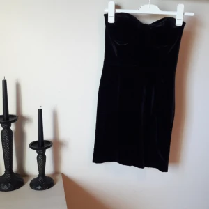  - FRI FRAKT. Jättefin bandauklänning i svart sammet. Bustiermodell. Sitter väldigt smickrande. Är gummikant högst upp på insidan som gör att den inte åker ner. Märkt 36 men stretchig så sitter fint på en 34 med. 