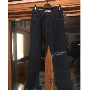  - Mörka jeans med ett hål i knäet och frayed längst ner på byxorna, dom har aldrig används 👖  Det står storlek L i dom med det är storlek 34 och midjan är ca 28-27 beroende på hur man vill att dom ska sitta. Kan fixa mer mått om du är intresserad.  Kan skickas men då står köparen för frakt. 48kr inte spårbart, 58kr spårbart. 📮  Det finns katter i hemmet 🐈