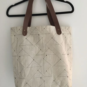  - Shopper från House Doctor. Stilren med svartvitt tryck och bruna läderhandtag. Vaxad insida och litet förvaringsfack. Frakt tillkommer.