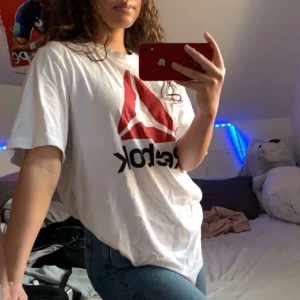 Vit reebok oversized tröja - Säljer denna fina oversized t-shirt. Inga fläckar, slitningar eller liknande på den. Använd men fortfarande i väldigt bra skick. Den är oversized då den är i men size L men passar jättebra på båda och skulle säga att den är ganska liten i storleken. Säljer för 150kr men pris kan ändras. 