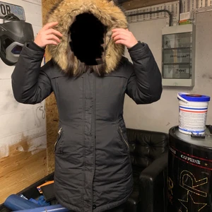 Saki sweden  - En svart vinterjacka från SAKI Sweden. Jackan är i fint skick förutom att en knapp har ramlat av (se bild). Den är i storlek 38(M) Luvan är äkta päls Nypris var 3800kr Priset går att diskutera