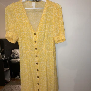 Gul blommig klänning - Lite liten i storleken