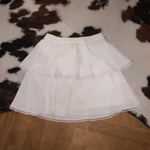 Volang kjol - Plisserad volang kjol som är as snygg men för liten. Har en topp till också som vildar ett matchande set som på bilden. Originalpris totalt: 2000kr. Rabatt vid köp av blus och kjol samtidigt