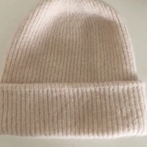 Mössa  - Säljer en ljusbeige/creme vit mössa från Bikbok som endast är använd 2 gånger så den är som ny.  Köpt för 199 kr säljs för 100