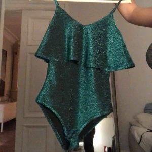  - Grön glittrig body perfekt till fest. Kan öppnas i grenen. Köparen står för frakt:)