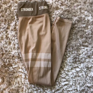 Stronger tights - Ett år asfresha slutsålda beiga Stronger träningstights. Jag köpte dem för ca. Ett år sen men tränar inte ofta för att hinna använda dem! Har använt dem 3 gånger, så de är fortfarande i bra skick