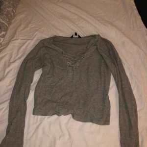 Kort topp med snörning - Använd men i bra skick. Kortare topp, sitter bekvämt och är i tunnare tyg