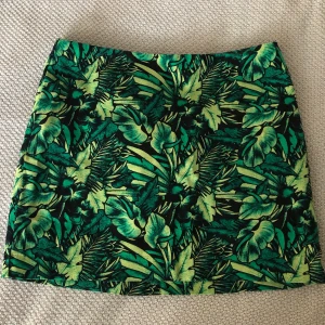 Växt-mönstrad kjol  - Mycket fint mönstrad kjol från hm i stl 36. Kjolen har en dragkedja på baksidan. Kjolen är inte använd och helt i nyskick då den tyvärr var liten i passform.