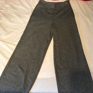 Utsvängda kostymbyxor  - Jättesnygga byxor från Gina tricot! S. 34 Sitter tajt runt midjan och rumpan (jag har ju då en ganska stor rumpa så om man har lite mindre sitter dom nog perfekt)  och med lite utsvängda ben. Dragkedja på sidan så den är diskret. Perfekt längd på mig, är själv 166 cm. Använda 1 gång! 