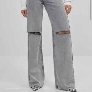 Bershka jeans utsvängda jeans med revor - Super snygga jeans från bershka som jag verkligen letat länge efter. Tyvärr köpte jag en för liten storlek och där med ska skicka dem vidare. Aldrig använt dem då dem är för små i midjan, helt nya. Hittade dock en fläck på baksidan som jag tror endast är ifrån produktionen. Köparen står för frakten. Ordinarie pris: 399kr Nypris: 350kr