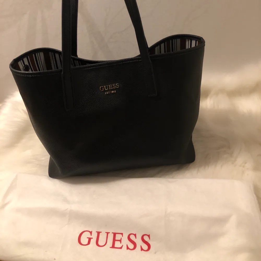 En större Guess väska som går att ha på två vis, svart läder. Liten pouch medföljer!. Väskor.