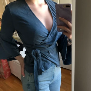 Blå omlott tröja  - En blå omlott topp med snörning och utsvängda ärmar från Lindex. Stl S💓 Köparen står för frakten!💋