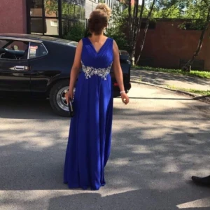 Balklänning passande S.  - Uppsydd, jag är 160cm och bar skor med 5cm klack på fotot. Passar S/M då det är stretch i ryggen. Finns en fläck framtill under bysten vid klänningens fall, en fläck baktill och små vid bysten. Inget jag själv provat tagit bort. Syns ej väl pga fallet på klänningen och veck. Kort på detta skickas vid intresse! Finns även matchande flyga för herr till! Är en unik klänning som jag lovar att ingen har en lika av! 500kr men är inte omöjlig kring priset. 