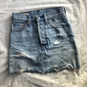 Levi’s jeanskjol strl 23 - Levi’s jeanskjol i storlek 23. Säljer på grund av att den är för liten på mig. Köpt för ungefär 2 år sedan. Ljus tvätt med slitningar fram och bak.🦋