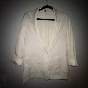 Kavaj i krämvit stl 40 - Snygg och stilren kavaj i stl 40 från H&M. Använt skick. Kommer från djur- och rökfritt hem. Frakt tillkommer!