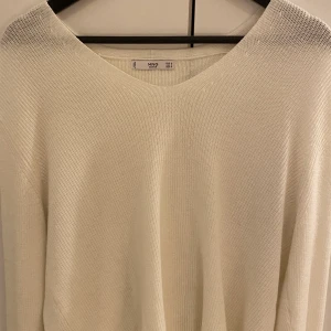 Stickad tröja - Säljer denna fina stickade tröja från Mango! Den är vit med en liten v-ringning och är som ny! Nypris 300🥰