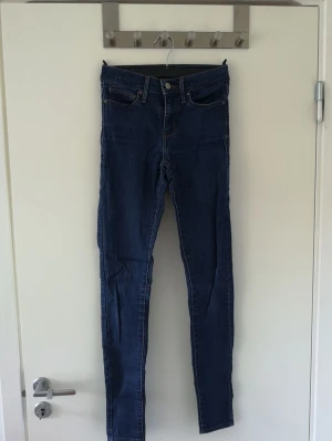 Leviś Slimming super skinny jeans - Mörkblåa Leviś Slimming super skinny jeans i bra skick. Storlek 25 vilket skulle kunna ses som XS. De är ganska långa i storleken. Köparen står för frakt⚡️