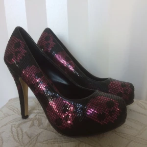  - Jätte snygga skor från Iron Fist. Svarta/rosa paljetter med mönster som döskallar. 
Endast använda vid plåtning, lite skavd på insidan av den högra skon. Inget som syns.