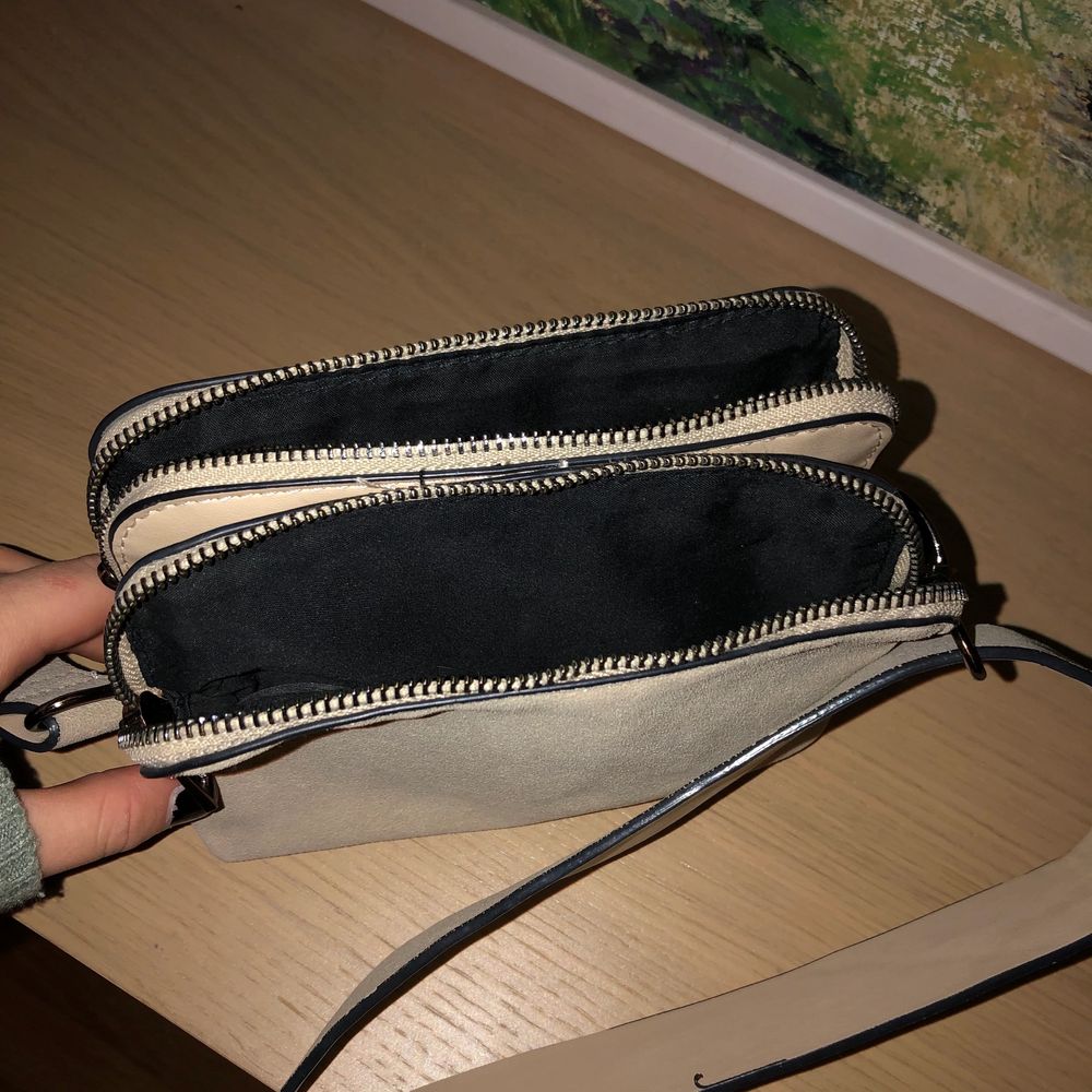 Säljer denna beiga väska från Lindex. Använd en del förra året men det finns inga defekter på väskan. Man kan justera axelbandet och både ha den som en axelremsväska och som en cross body bag. Den har två fack.. Väskor.