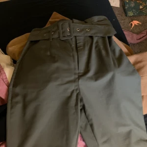 Nakd kostymbyxor  - Mörkgröna kostymbyxor från nakd! Använda ett fåtal gånger, så de är i bra skick! Uppsydda så att de passar lite kortare personer, jag är 1,60. Snygg färg till hösten