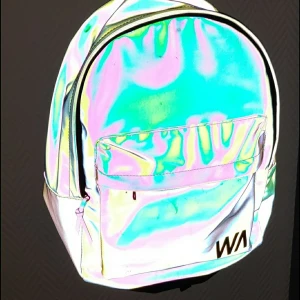 Reflex ryggsäck - Reflex ryggsäck som ändrar färg i ljuset. Den är i toppen skick då den inte har använts! Passar perfekt till dom som inte vill använda reflexväst, nu till höst eller bara vill ha en cool ryggsäck + frakt 63 kr✨💜 