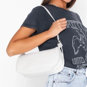 Väska från nelly - Säljer min väska från nelly då jag har köpt en ny. Denna är slutsåld på deras hemsida! Använd en del vilket syns framförallt i väskan, men det är ganska lätt att tvätta rent om man är petig. Supersnygg och trendig! 100kr + frakt eller bud, BUD PÅ 110kr🥰