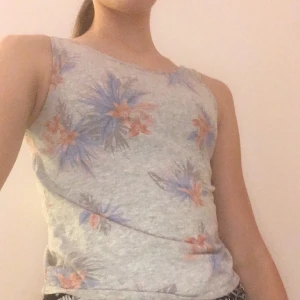 Grått linne med blommönster  - Fint linne i gott skick och fin detalj i ryggen. Inte särskilt använd. 