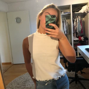 Vit topp - Vit topp med volang vid halsen och längst ner på tröjan, tröjan är använd Max 2-3 ggr och det är därför den säljs. Stretchigt material. Supersöt topp att ha båda till fest och vardags! 