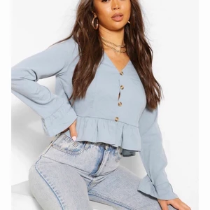 Ljusblå topp  - Jättefin ljusblå topp med knappar och volanger i storlek 36. Helt oanvänd med alla lappar kvar 