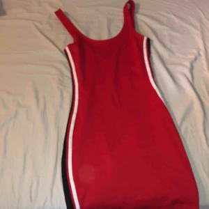 -  Supernsygg tajt röd klänning med 2 ränder längst med kroppen vid sidorna i svart och vit. Den följer ens kurvor perfekt! Använd 1 gång 🥰  Du står för frakten!