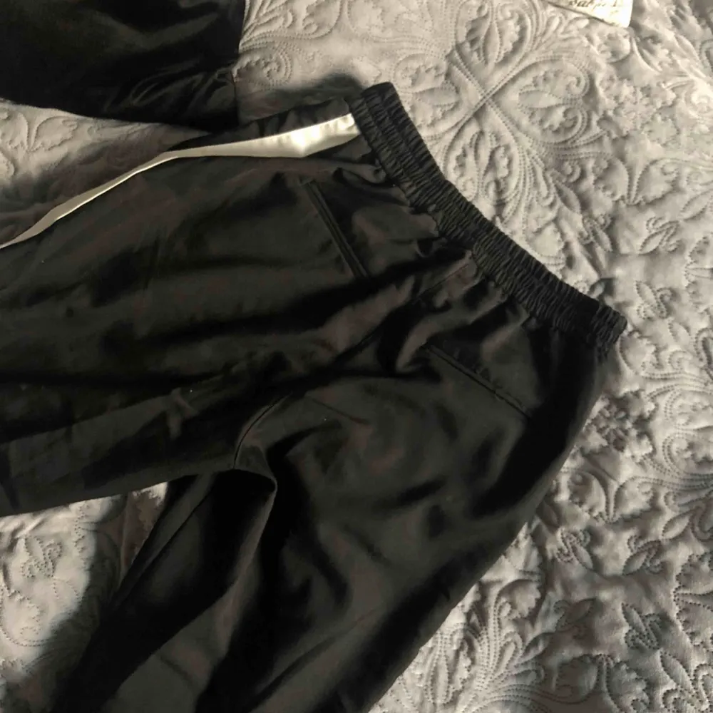 Coola svarta kostymbyxor med vit rand på sidorna! Använd max en gång och är i nyskick som när den var köpt!🥶  (Priset kan diskuteras);). Jeans & Byxor.