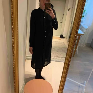  - Genomskinlig klänning med pärlemoaktiga knappar