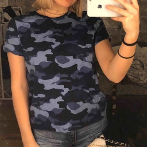  - Blå camo T-shirt från NA-KD med öppen rygg. Köparen står för frakt på ca 50kr😊