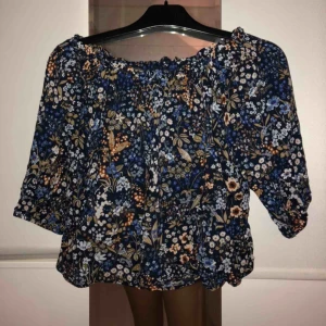  - Blommig off shoulder blus