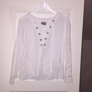  - Jättefin vit blus med spetsmönster och knytning! Stor i storleken (enligt min smak) då det står att det är en XS och jag är en S och tycker den sitter löst, så därför säljer jag den! Köparen står för frakten 