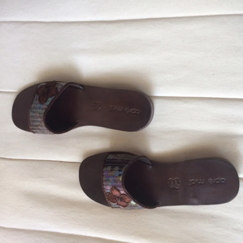 Wooden brown slip-ins from apré midi. Sequence on top with a decorative flower. Small 38. Try them out!. Skor.