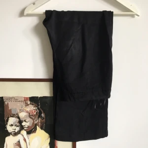  - Tunna byxor i blankt material. Lite kortare i benen, slutar ca 1 dec innan ankeln. Dragkedja i sidan