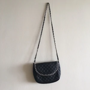  - Svart väska med silvriga detaljer. 