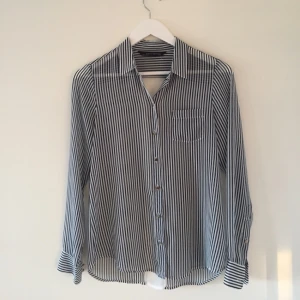  - Skjorta i tunt tyg från Zara. Randig i blått och vitt. En liten reva på framsidan som knappt syns. 