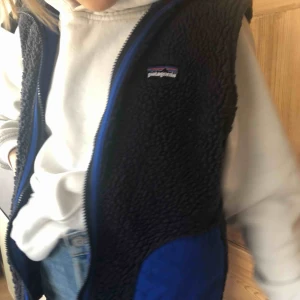 - Patagonia ull väst i en mörk lila med blåa detaljer. Väldigt unik och snygg. Säljer endast pga att jag har två. Pris är flexibelt.