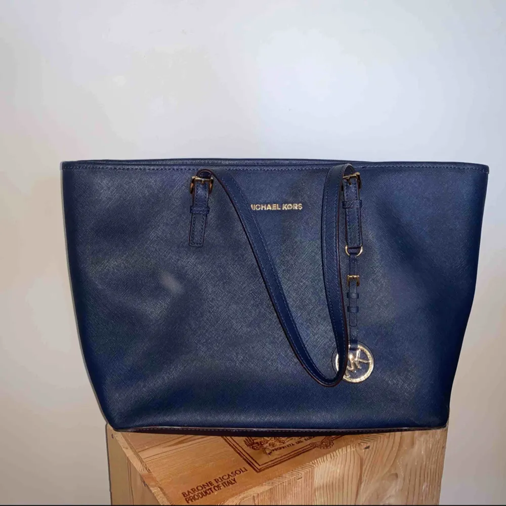 Denna Michael Kors handväska är i modellen Jet Set medium tote och färgen marinblå. Väskan är i princip helt utan slitage och generellt i ett mycket gott skick. Inköpspriset var 2700 kr. Väskan är självklart äkta och köpt från NK i Stockholm. . Väskor.
