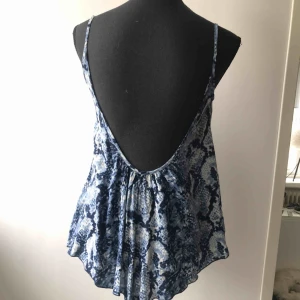  - Ormmönstrad topp i blå/vit med djup rygg. Köparen står för frakten 🦋
